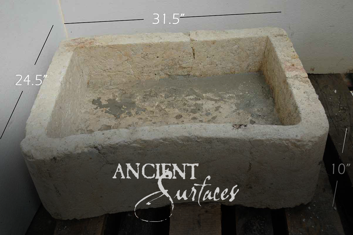 Deep weathered cream limestone farmhouse basin with pink and ochre staining