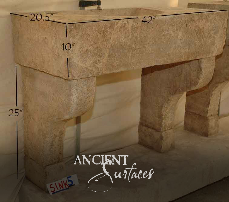 Double-basin beige travertine console sink raised on four carved stone legs