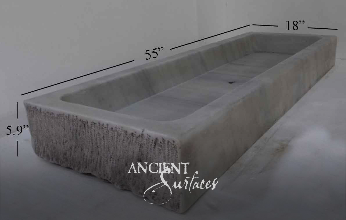Long grey marble trough with polished interior, twin drains and rock-faced sides