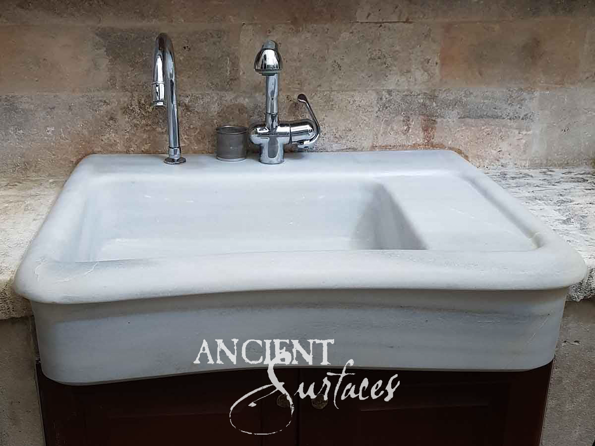 White glazed apron-front sink with integral drainboard, backsplash and chrome faucets